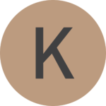 K-siiven symboli hiekan värisellä pohjalla