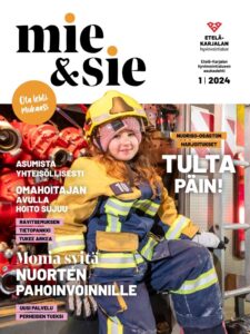 Kuvassa Mie&Sie-lehden kansikuva, jossa palomiehen pukuun pukeutunut hymyilevä tyttö istuu paloauton oviaukossa ja katsoo kameraan. Kuvassa on paljon oranssia, keltaista ja tummansinistä väriä.