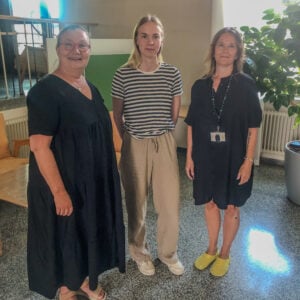 Kuvassa kolme naista seisoo rinnakkain sairaalan aulatiloissa. Kirsi, Ester ja Niina ovat haastateltuina artikkelissa.