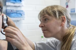 Lääkäri tutkii potilaan korvaa vastaanotolla.