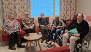 Ikäihmisiä, 5 naista, istumassa sohvalla keskustelemassa