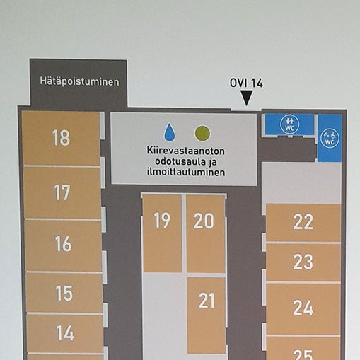 Lähikuva opastetaulusta, jossa näkyy tarkemmin kiirevastaanoton sisäänkäynti, ilmoittautuminen ja odotusaula.