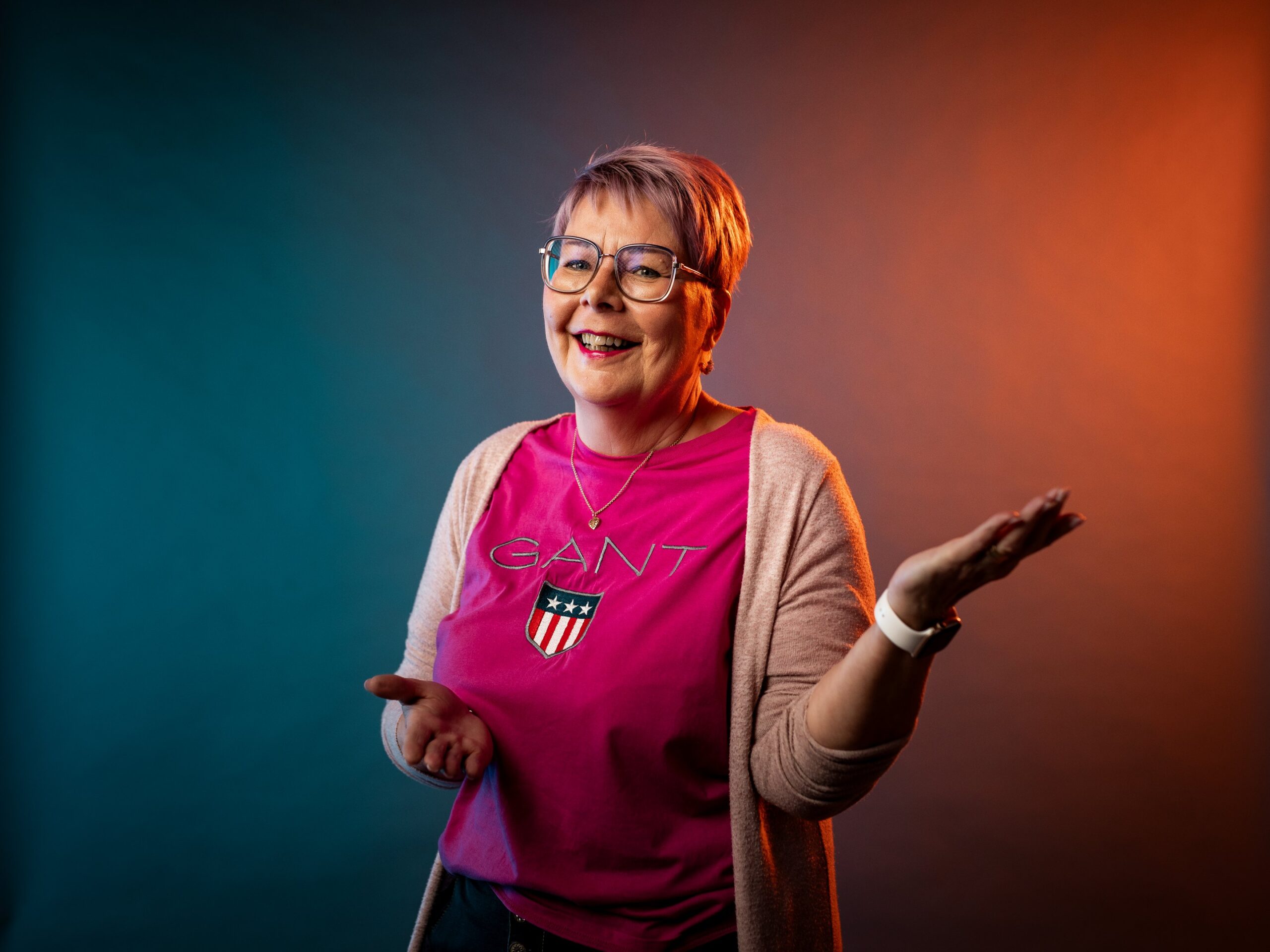 Studiokuva Annesta, jossa hän iloisena elehtii käsillään.