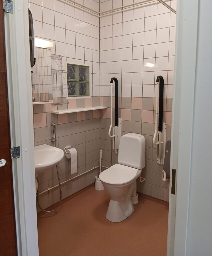 Wc, jossa wc-istuimen molemmilla puolilla tukikahvat.